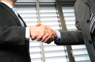 Image of 2 people shaking hands shows our attorneys work directly with businesses and with lawyers